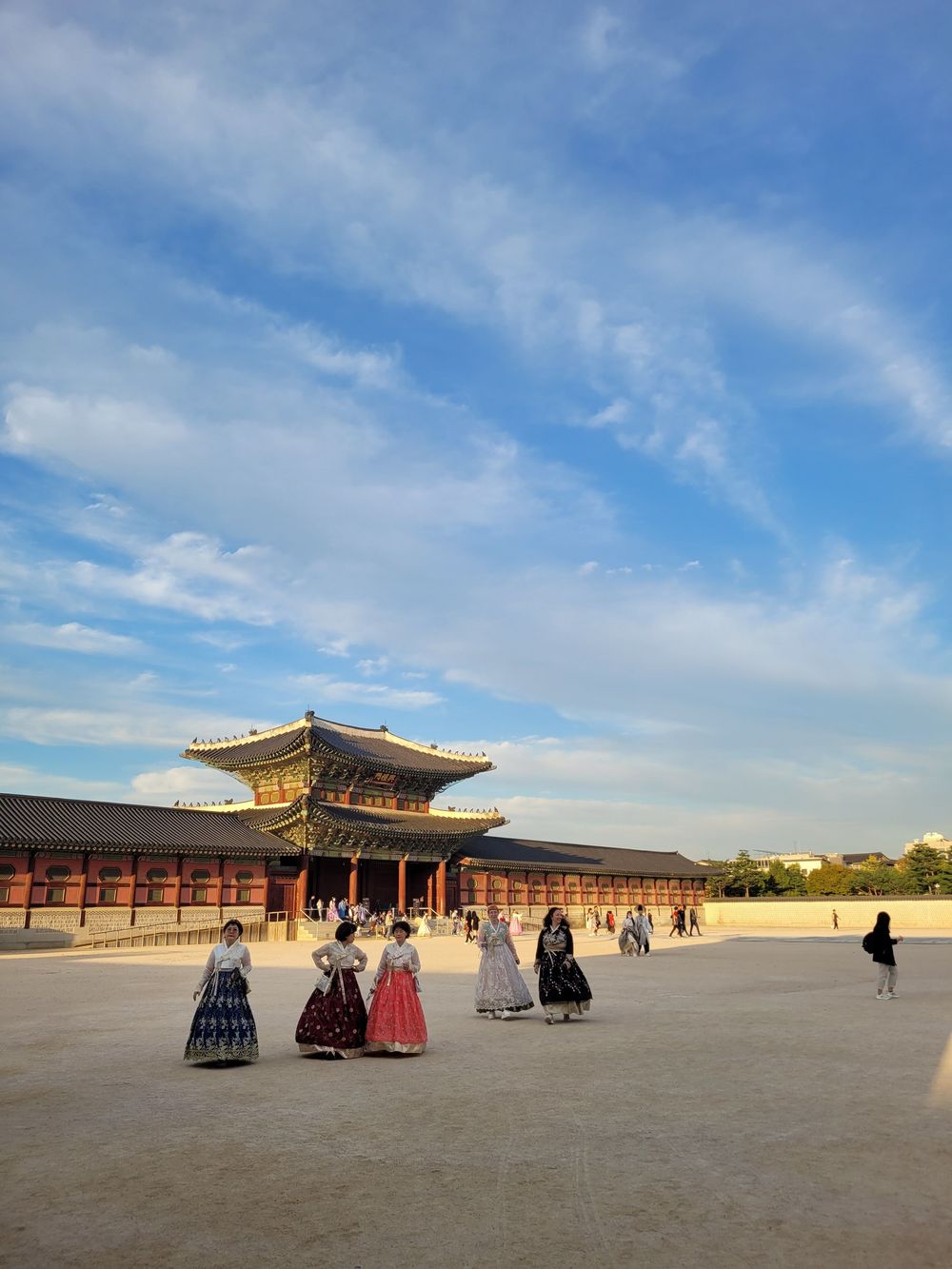 Visitors in hanbok crossing the main courtyard of Gyeongbokgung