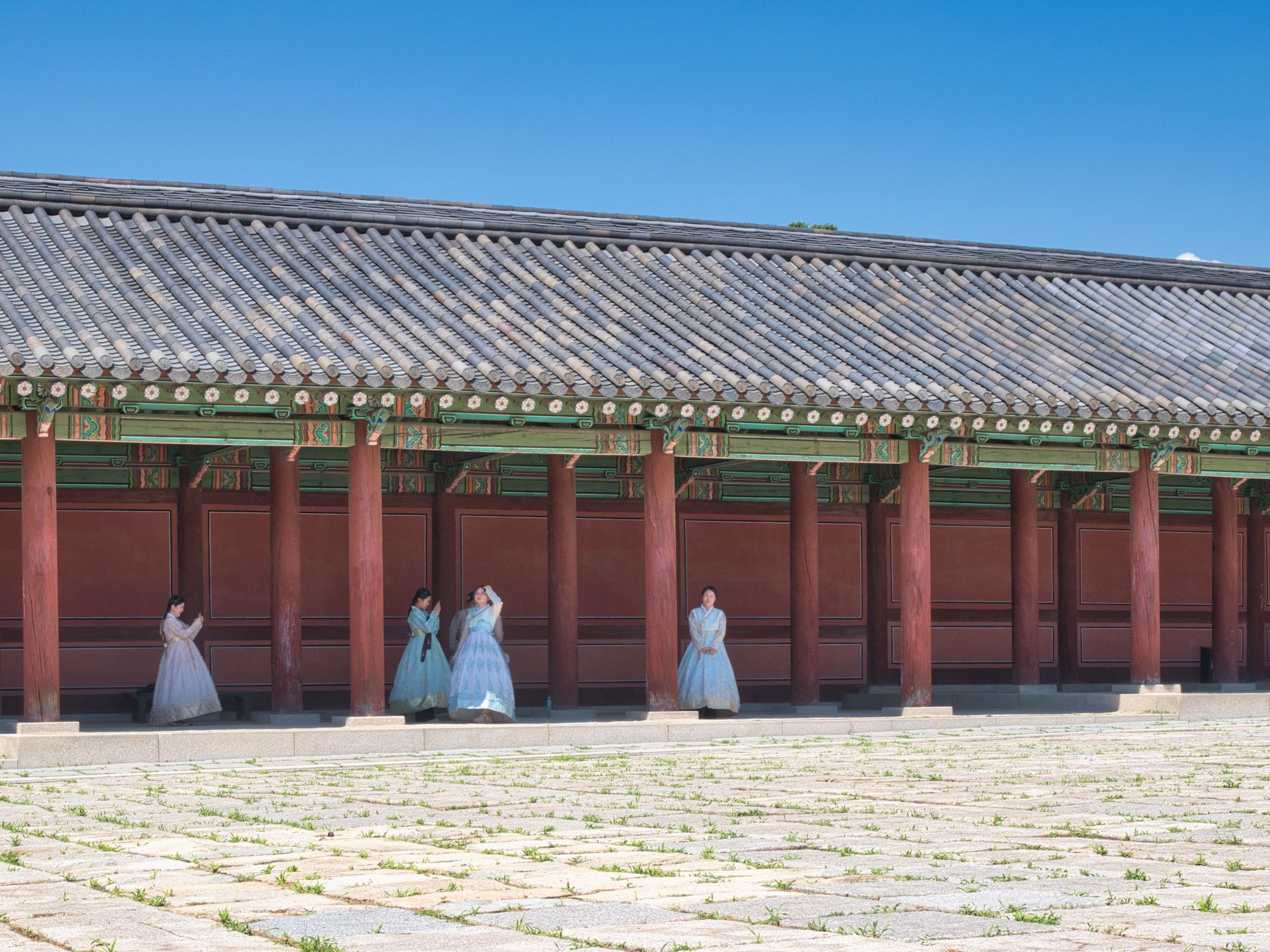 Women in hanbok standing in front of a palace hall in Seoul